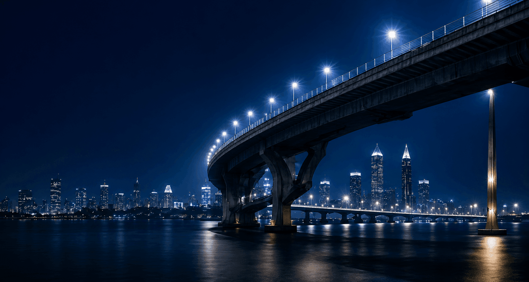 Suspension bridge at night representing the gap between AI pilot success and production scale.